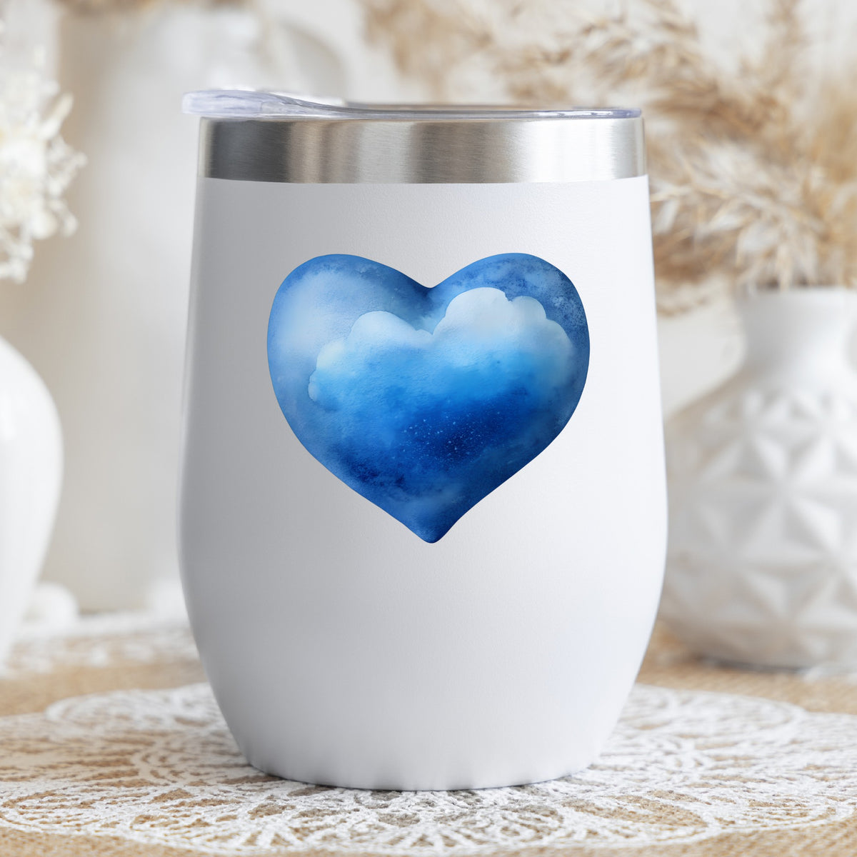 Blue Watercolor Heart With Clouds UV DTF sticker applied to a white stemless tumbler with a lid