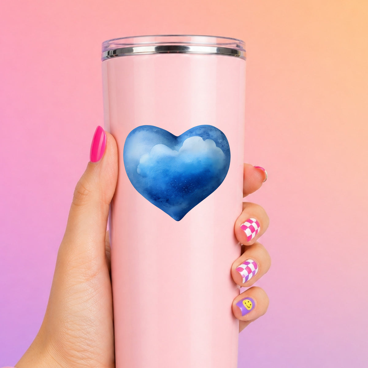 Blue Watercolor Heart With Clouds UV DTF sticker applied to a tall pink tumbler on a pink and orange background