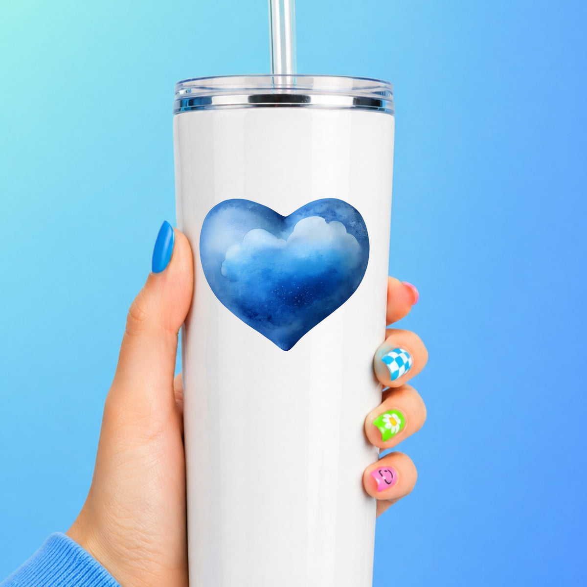 Blue Watercolor Heart With Clouds UV DTF sticker applied to a white straw tumbler on a blue background
