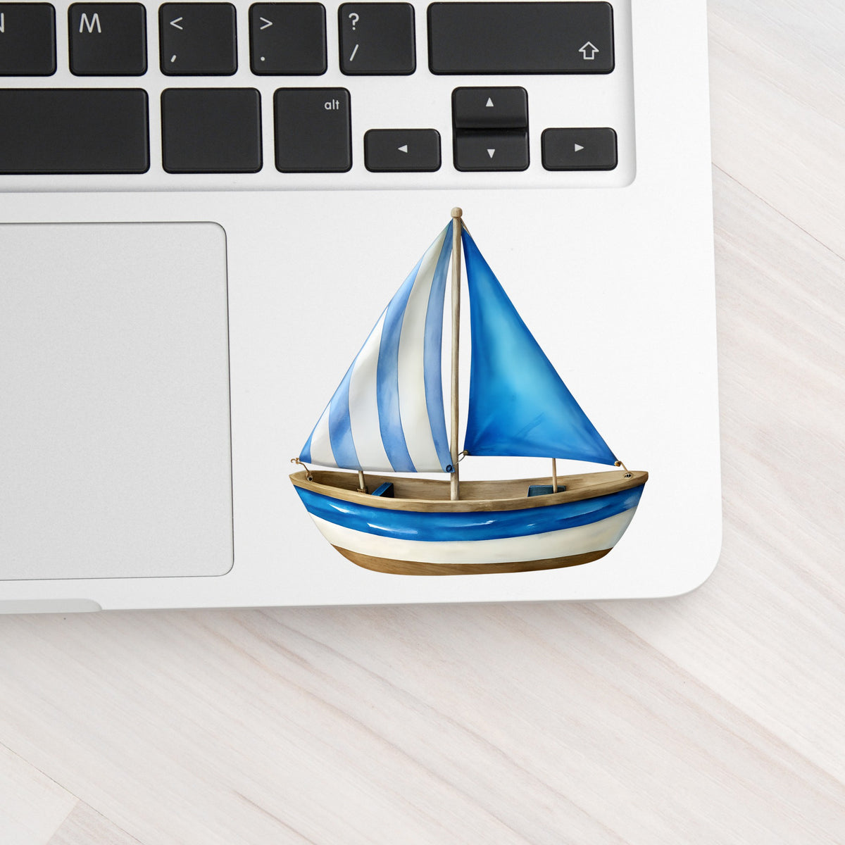 Blue Striped Sailboat UV DTF sticker applied to a silver laptop beside the keyboard