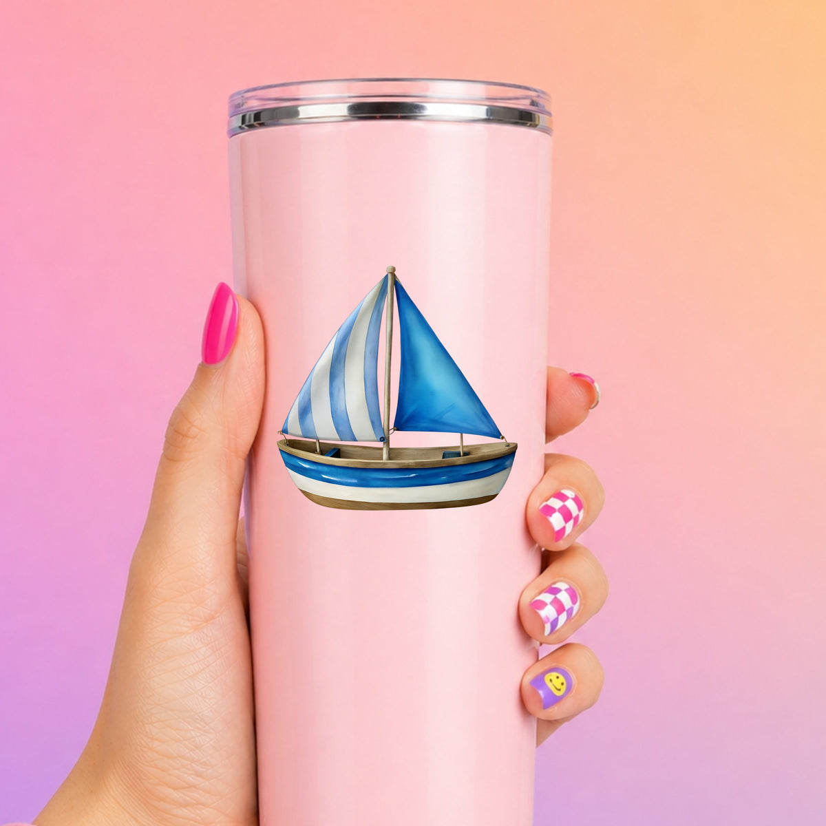Blue Striped Sailboat UV DTF sticker applied to a tall pink tumbler on a pink and orange background