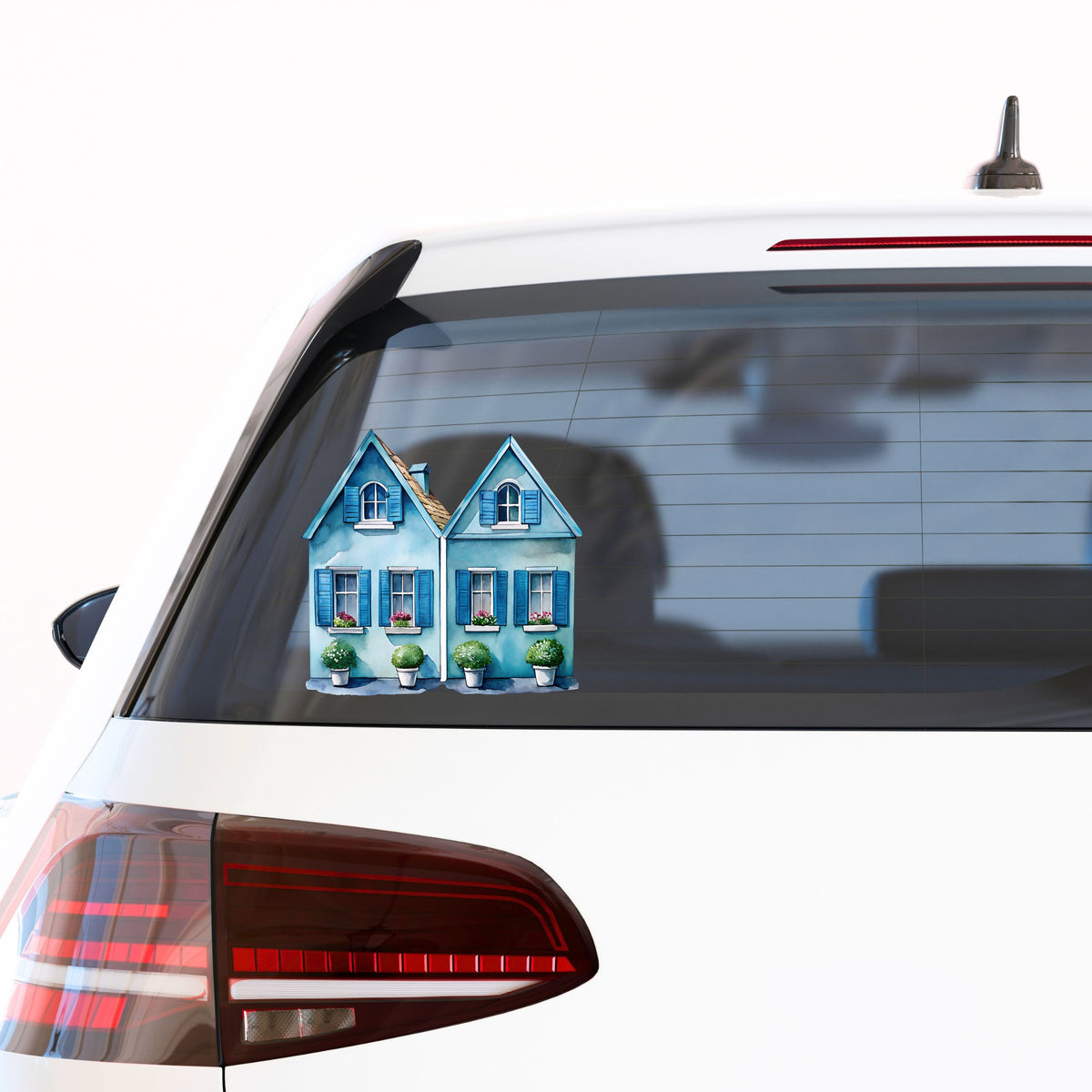 Two Blue Coastal Cottages UV DTF sticker applied to the rear window of a white car