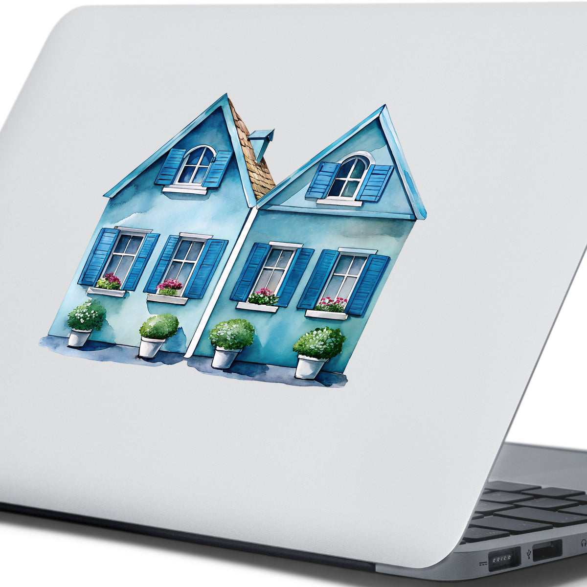 Two Blue Coastal Cottages UV DTF sticker applied to the lid of a silver laptop