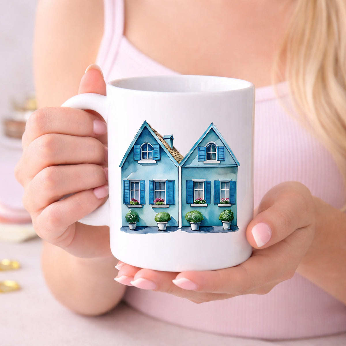 Two Blue Coastal Cottages UV DTF sticker applied to a white coffee mug held in both hands