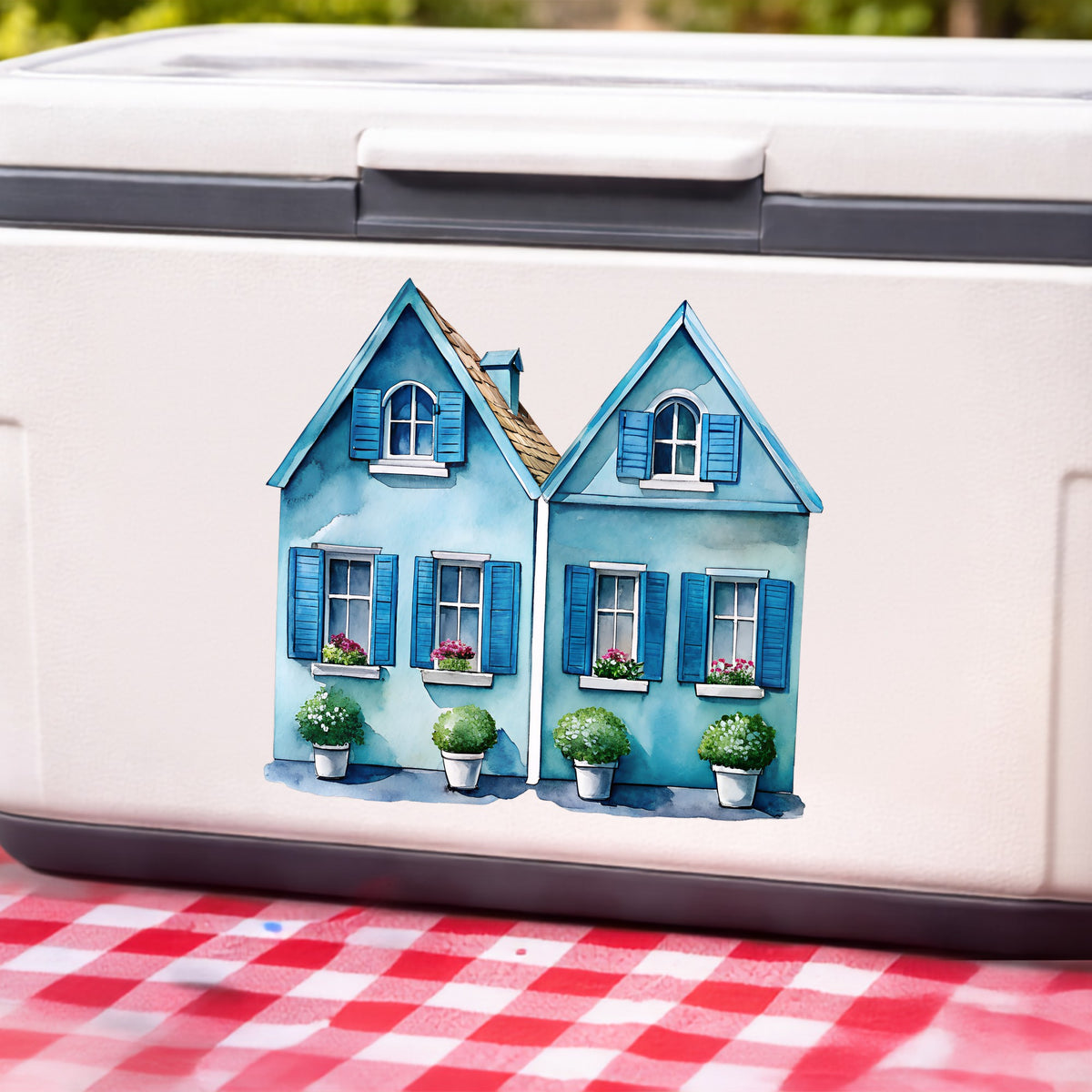 Two Blue Coastal Cottages UV DTF sticker applied to a white cooler on a red gingham cloth