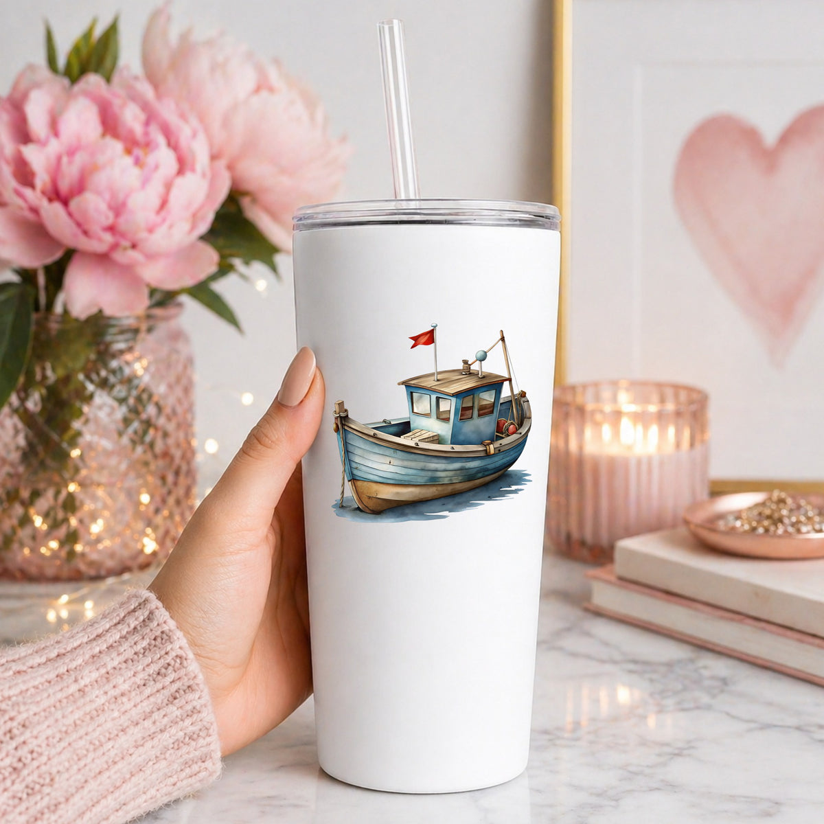 Wooden Fishing Boat With Red Flag UV DTF sticker applied to a white straw tumbler beside pink peonies