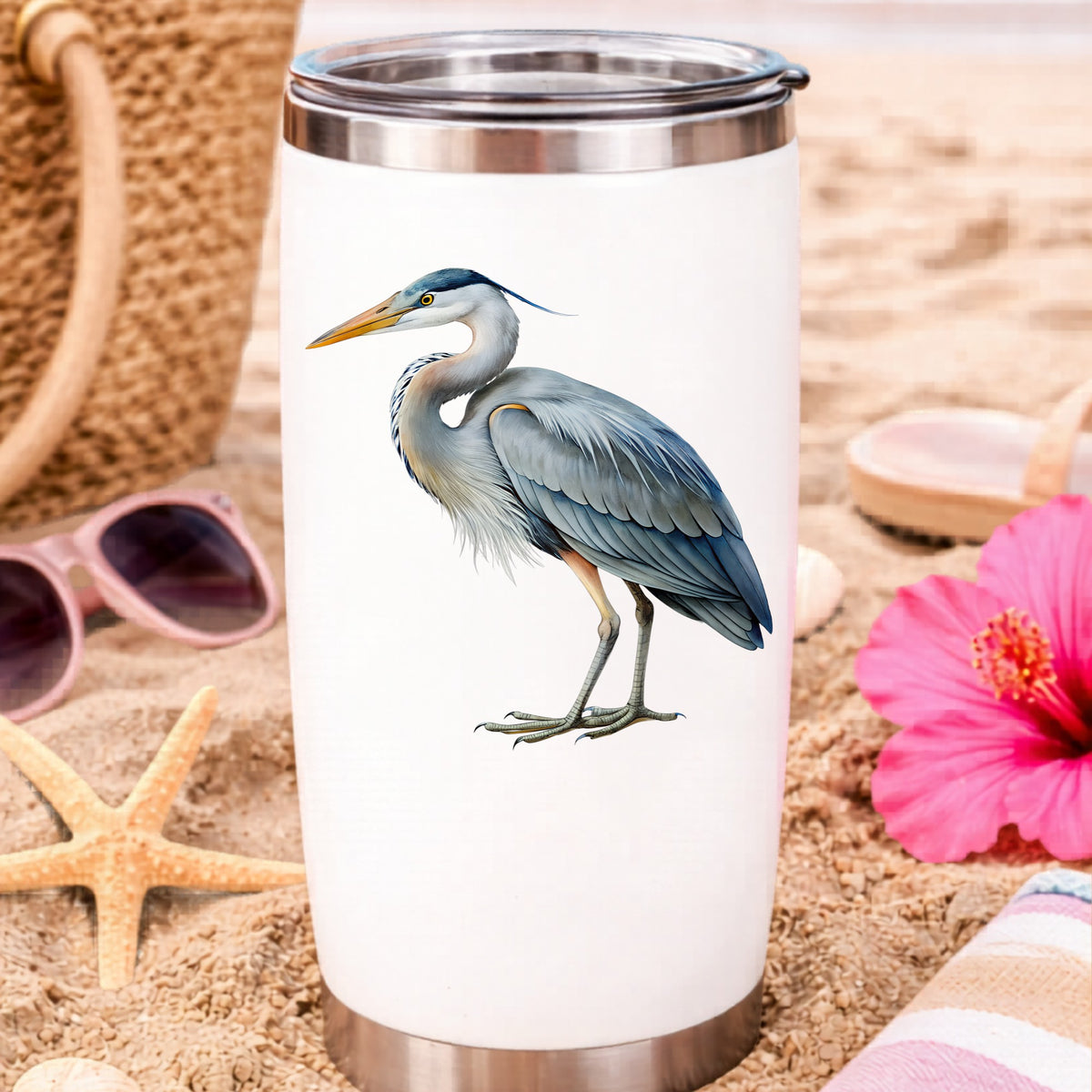 Great Blue Heron UV DTF sticker applied to a white travel tumbler on beach sand