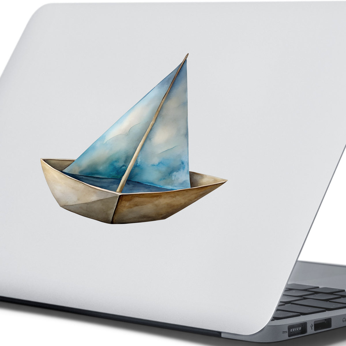 Paper Sailboat UV DTF sticker applied to the lid of a silver laptop