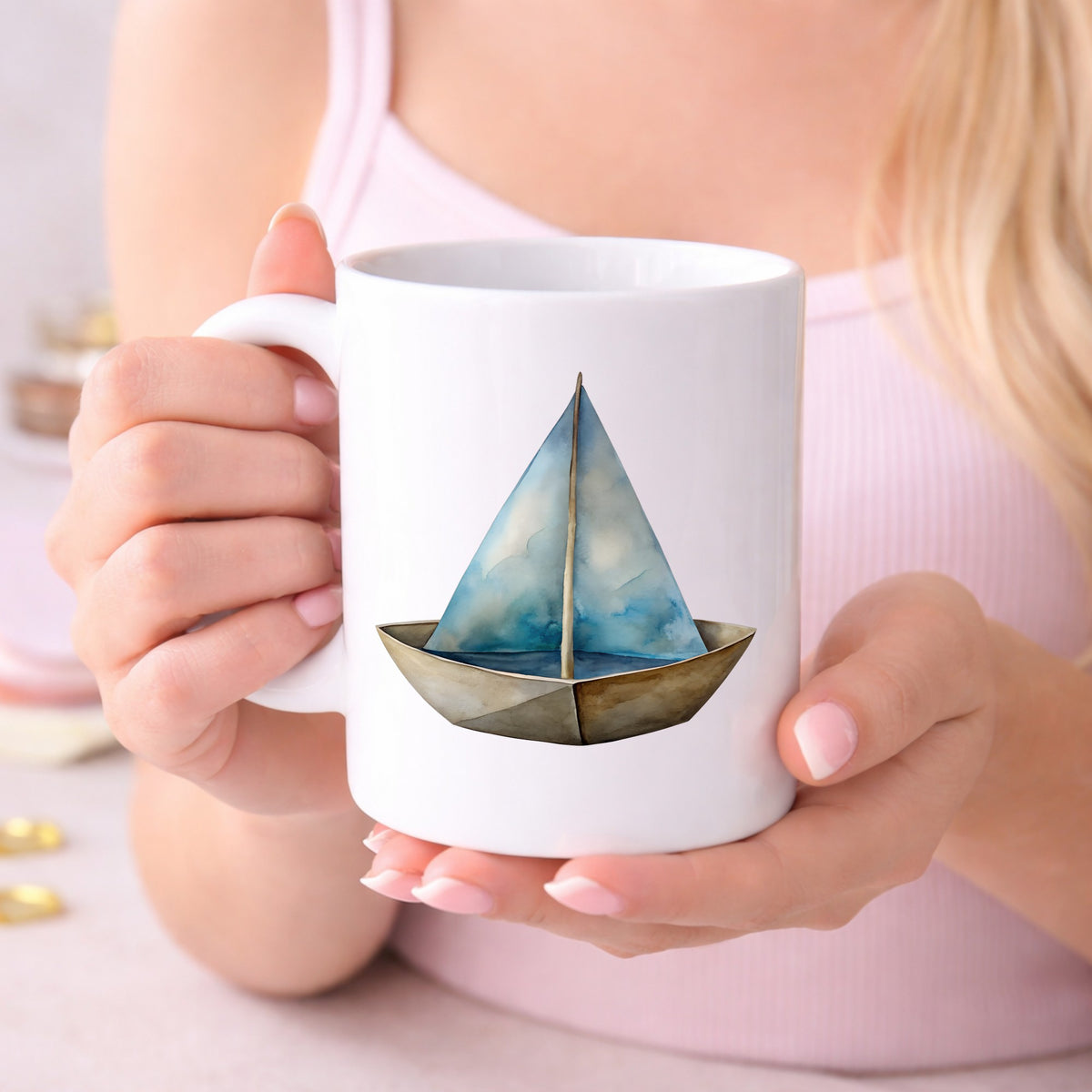 Paper Sailboat UV DTF sticker applied to a white coffee mug held in both hands