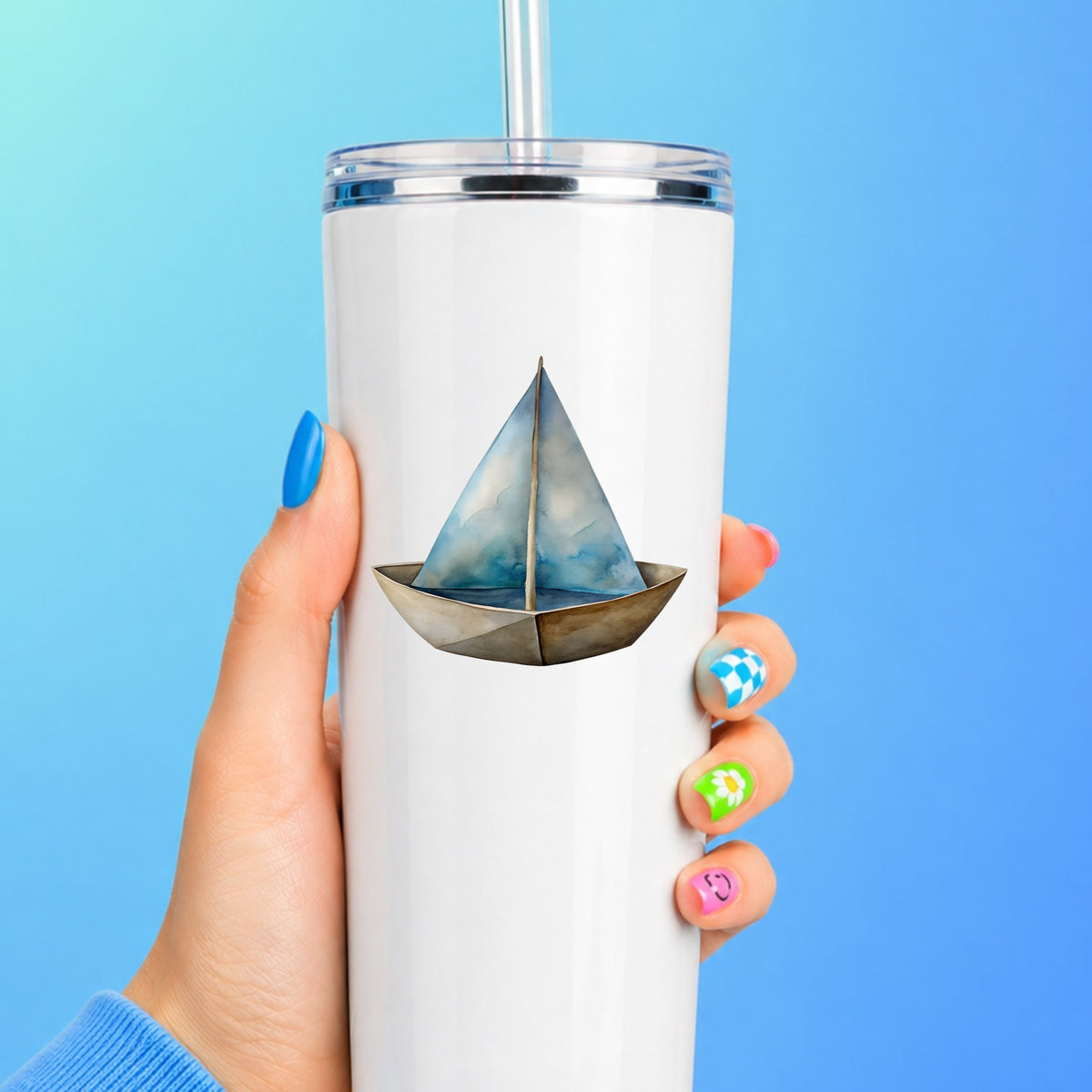 Paper Sailboat UV DTF sticker applied to a white straw tumbler on a blue background
