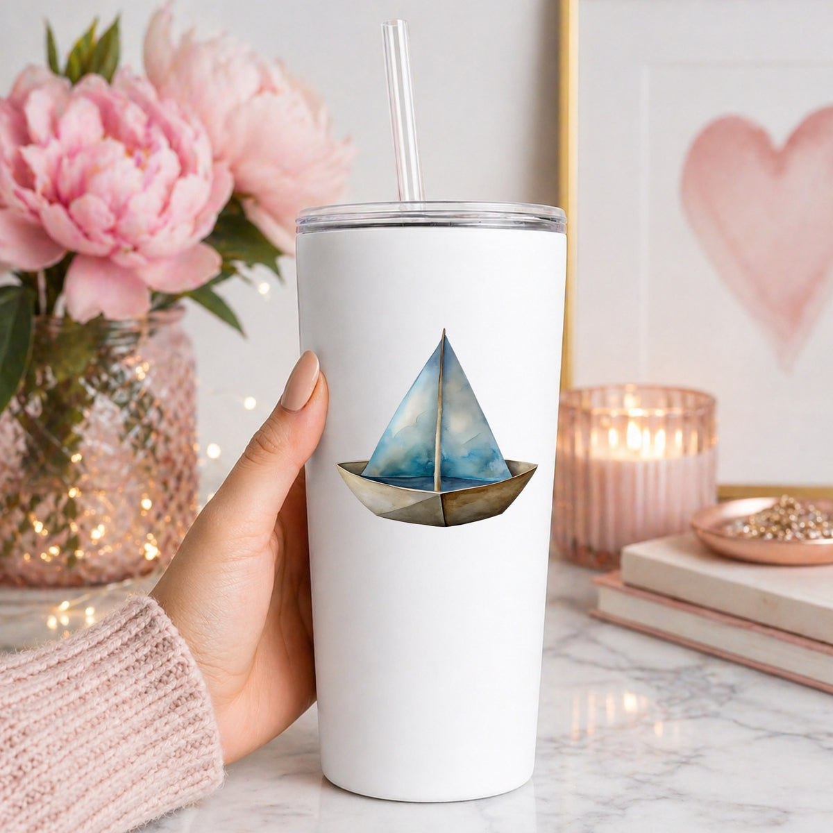 Paper Sailboat UV DTF sticker applied to a white straw tumbler beside pink peonies