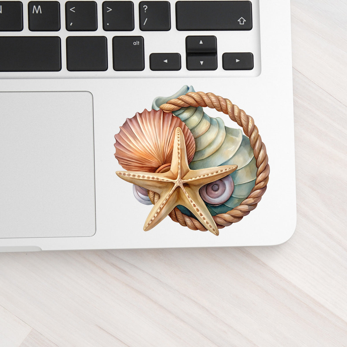 Seashells Starfish Rope Circle UV DTF sticker applied to a silver laptop beside the keyboard