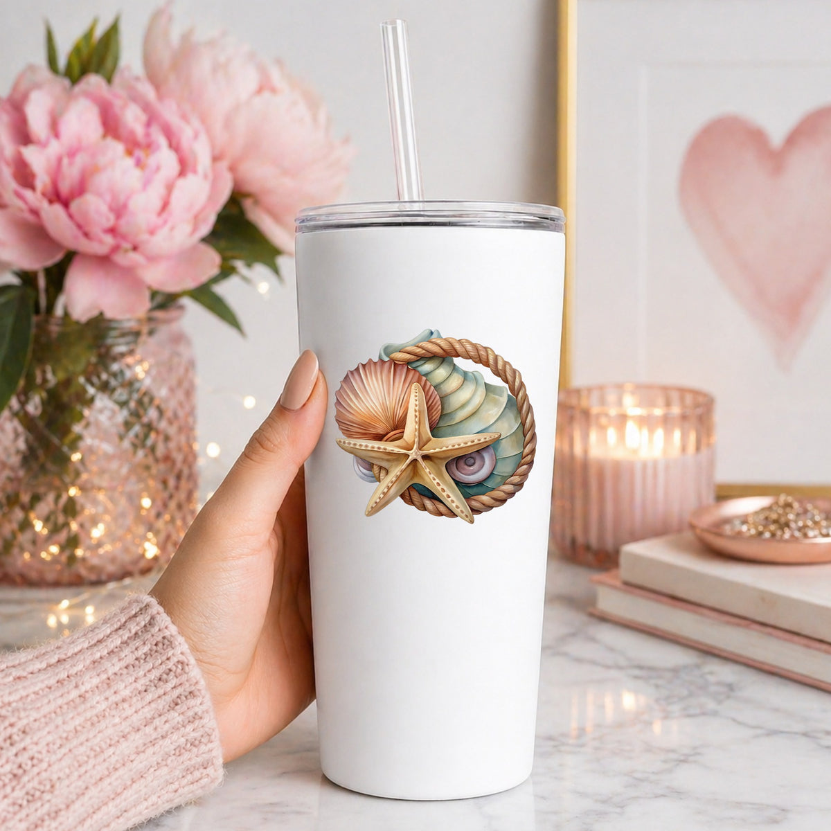 Seashells Starfish Rope Circle UV DTF sticker applied to a white straw tumbler beside pink peonies
