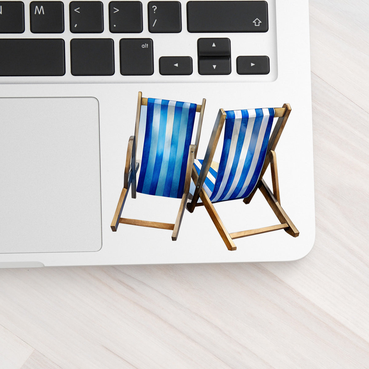 Two Blue Striped Beach Chairs UV DTF sticker applied to a silver laptop beside the keyboard