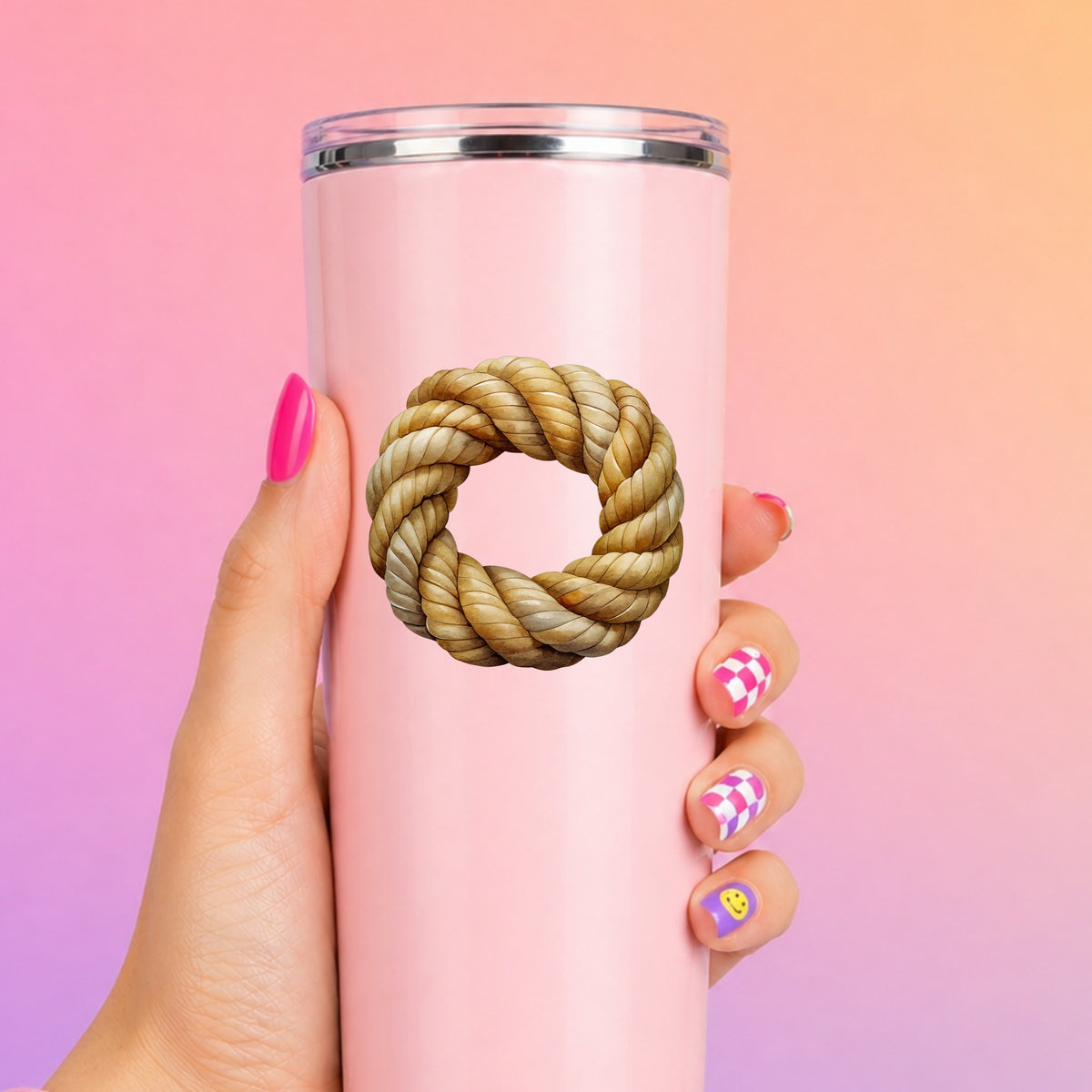 Rope Knot Wreath UV DTF sticker applied to a tall pink tumbler on a pink and orange background