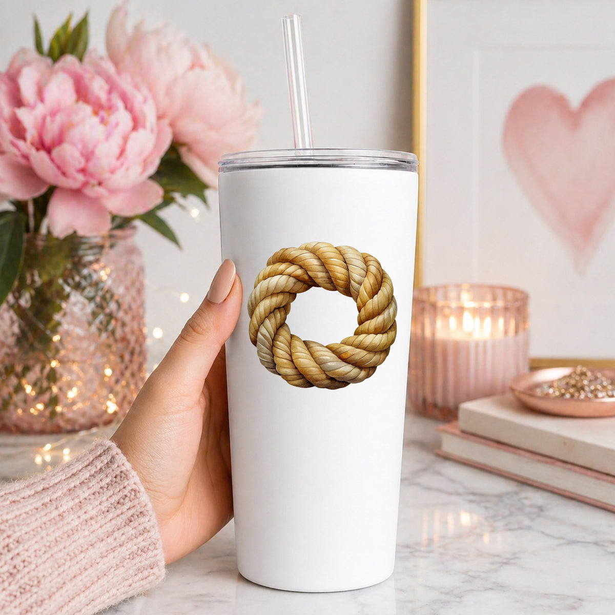 Rope Knot Wreath UV DTF sticker applied to a white straw tumbler beside pink peonies