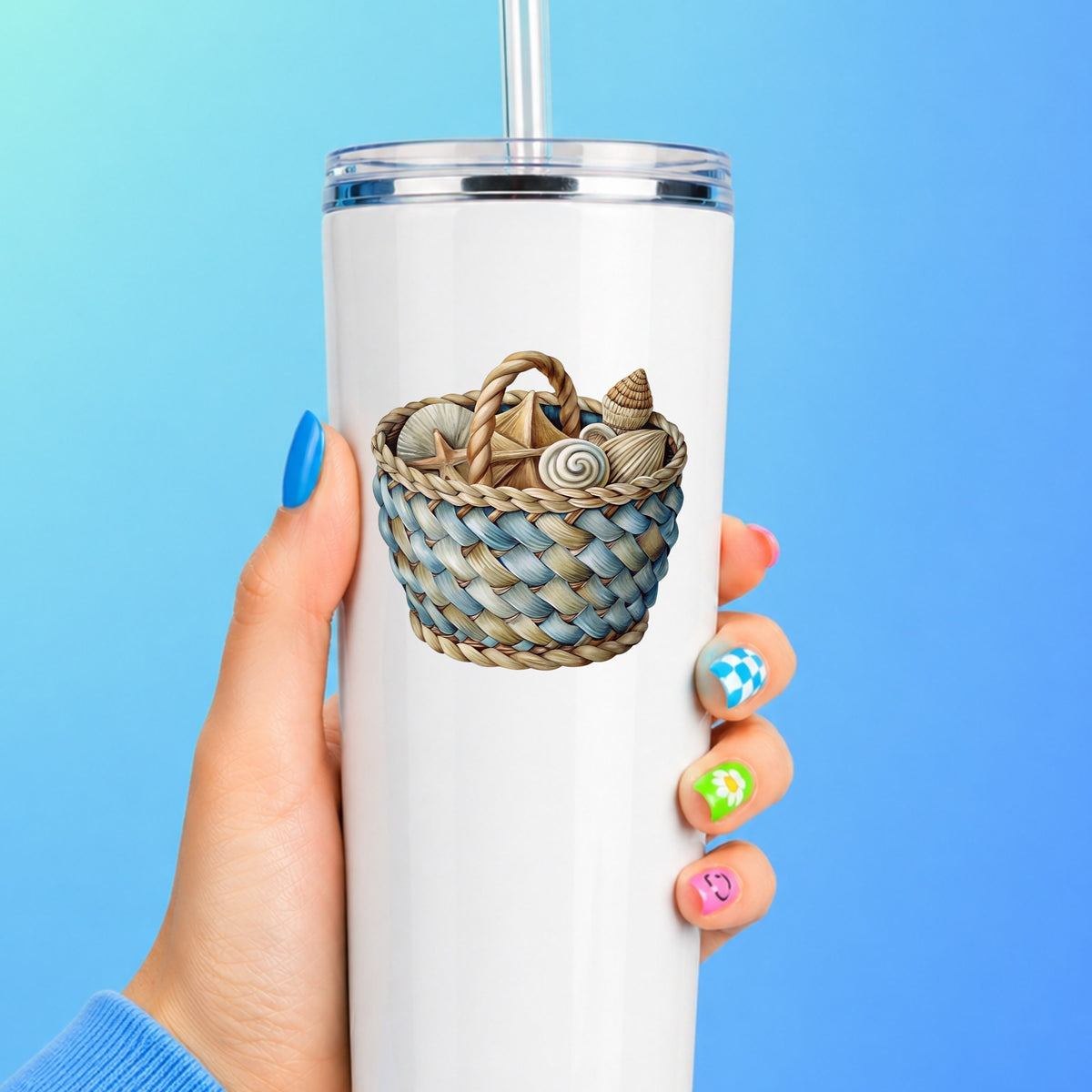 Woven Basket Of Seashells UV DTF sticker applied to a white straw tumbler on a blue background