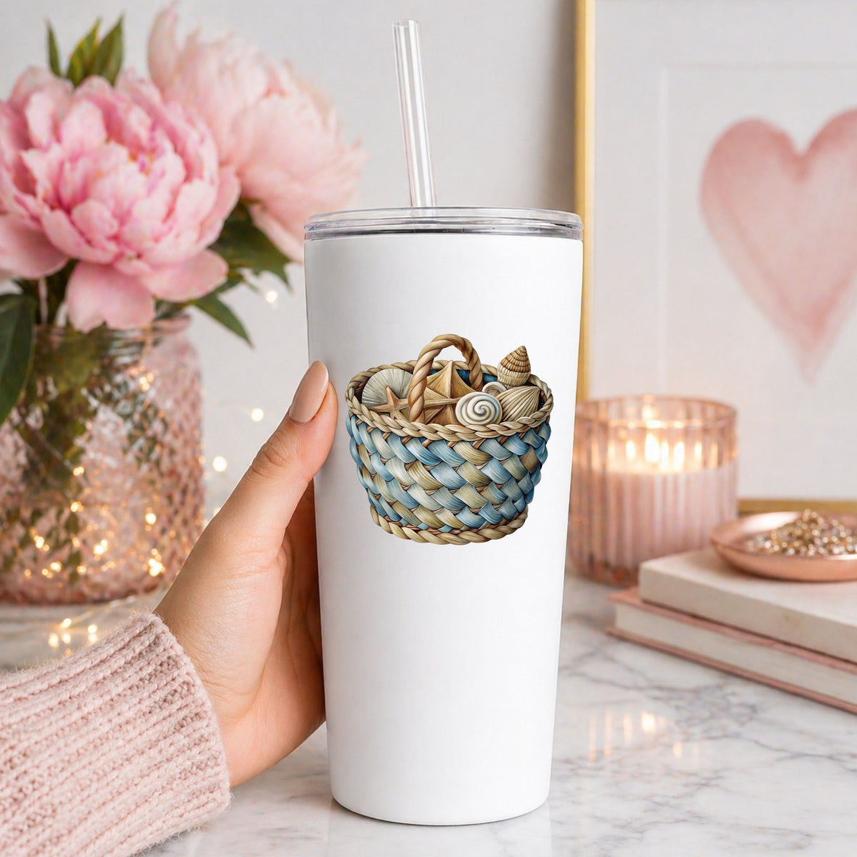 Woven Basket Of Seashells UV DTF sticker applied to a white straw tumbler beside pink peonies