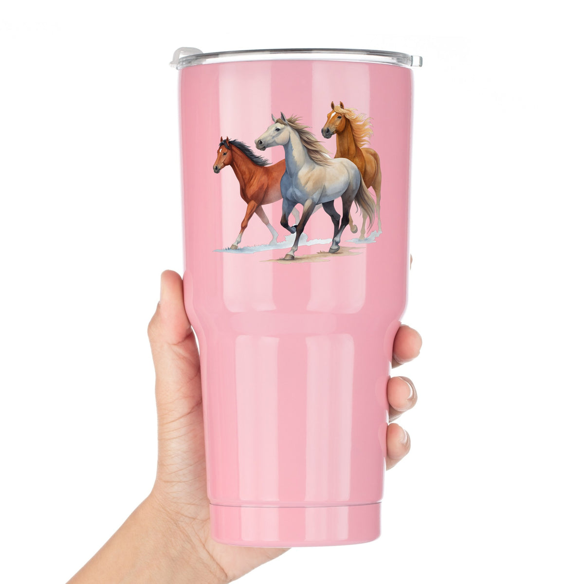 Three Horses Running UV DTF sticker applied to a pink tumbler held against a white background