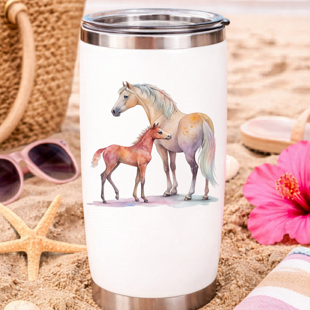 Pastel Mare And Pink Foal UV DTF sticker applied to a white travel tumbler on beach sand