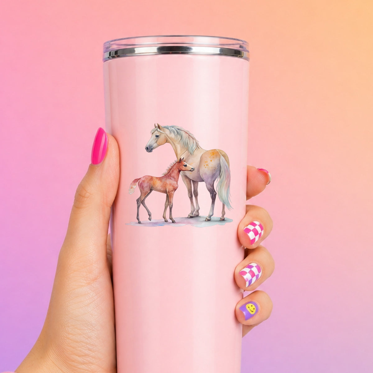 Pastel Mare And Pink Foal UV DTF sticker applied to a tall pink tumbler on a pink and orange background