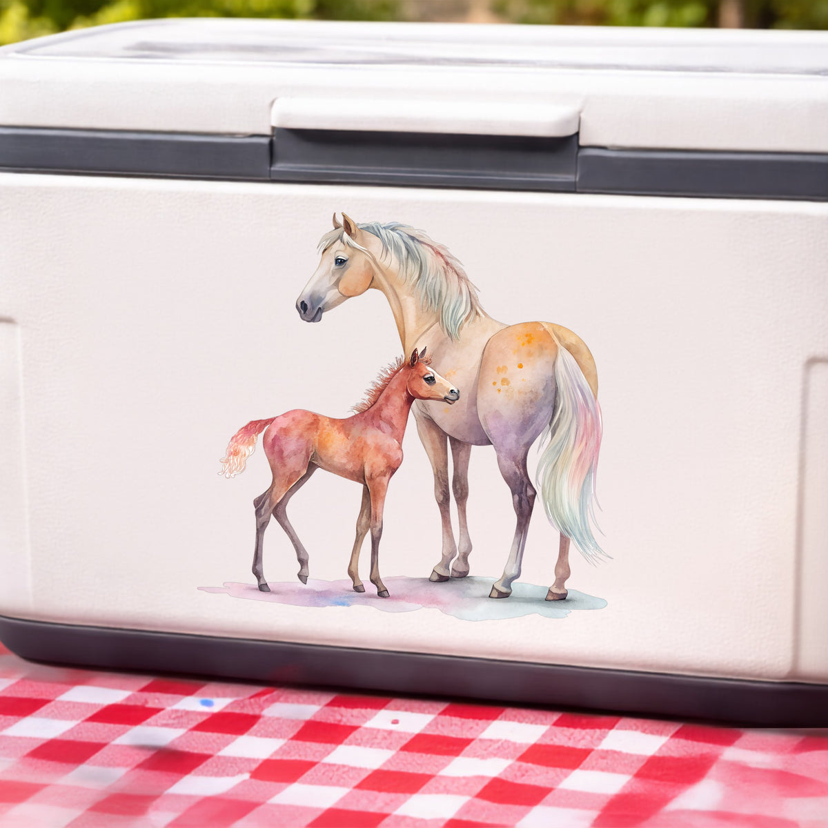 Pastel Mare And Pink Foal UV DTF sticker applied to a white cooler on a red gingham cloth