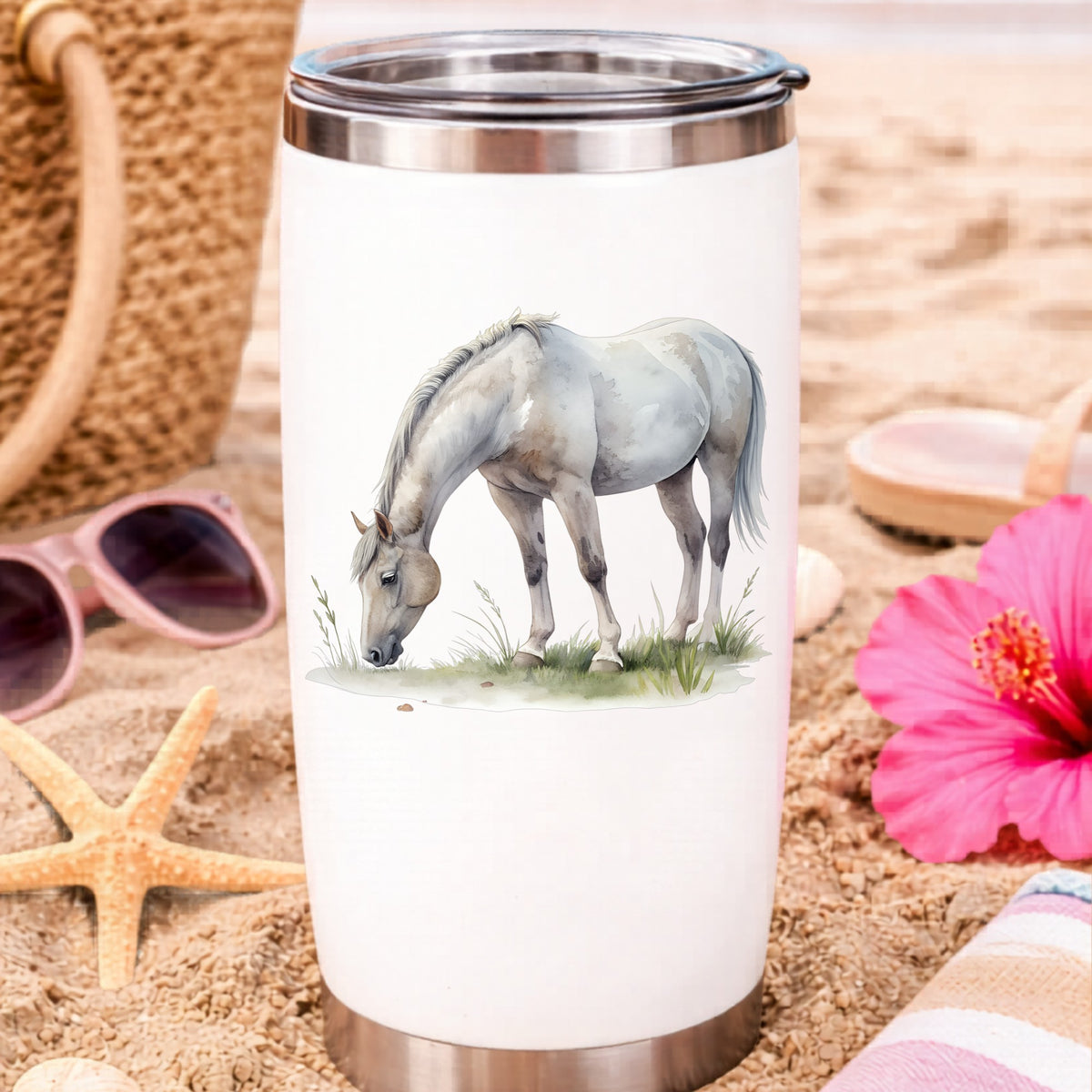 Gray Horse Grazing On Grass UV DTF sticker applied to a white travel tumbler on beach sand