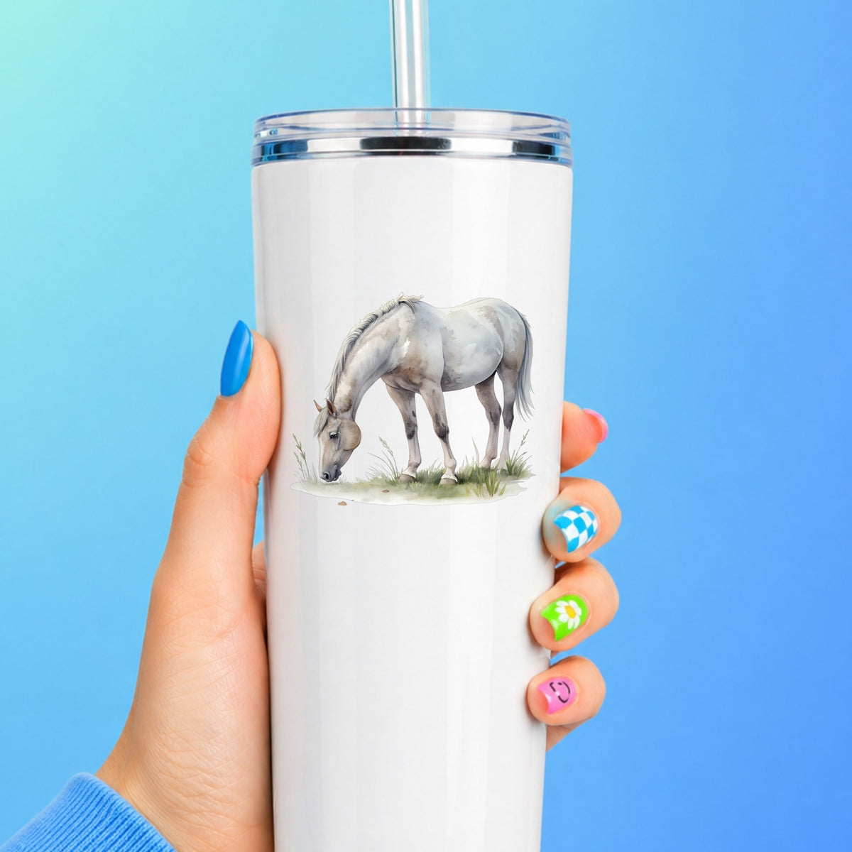 Gray Horse Grazing On Grass UV DTF sticker applied to a white straw tumbler on a blue background