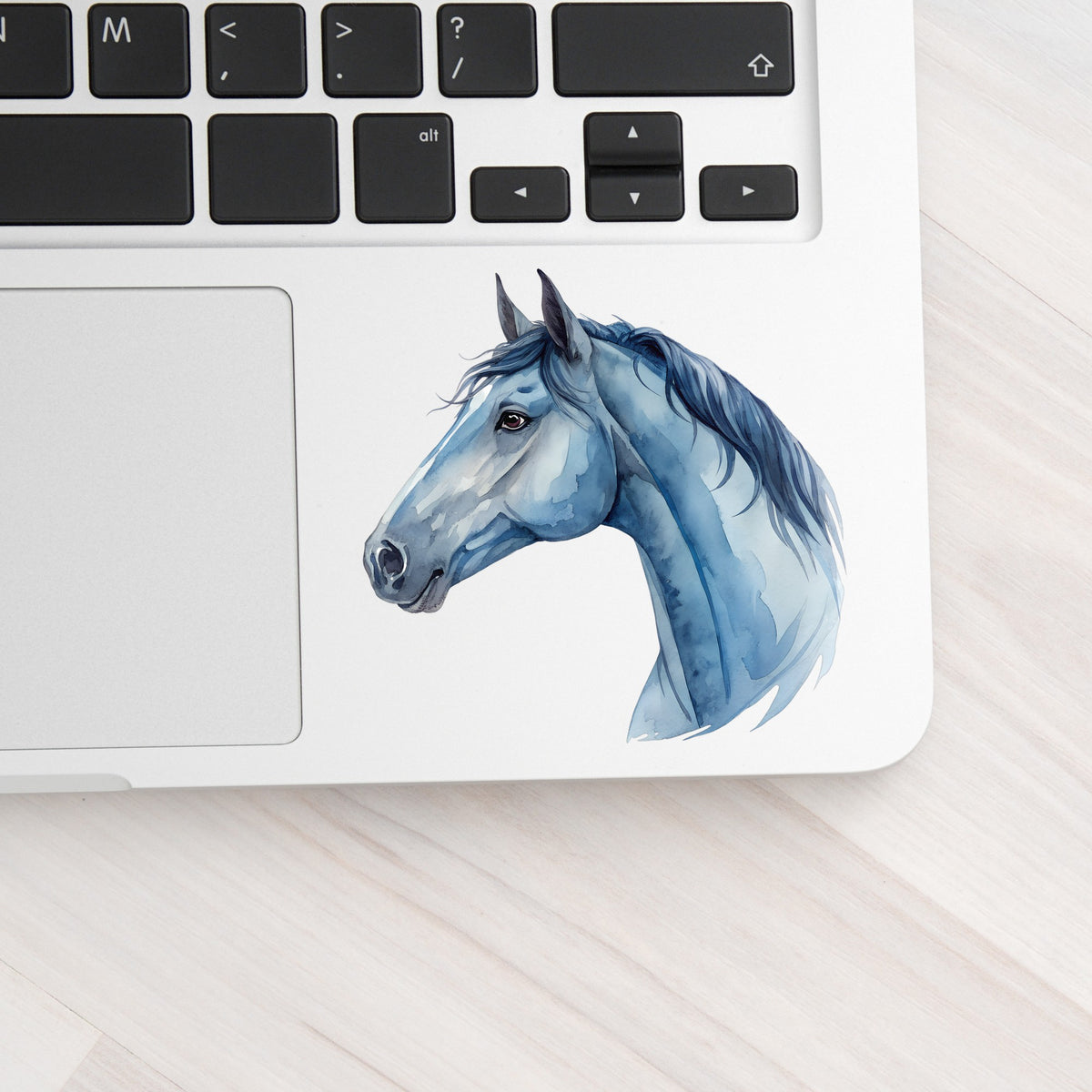 Blue Horse Head UV DTF sticker applied to a silver laptop beside the keyboard
