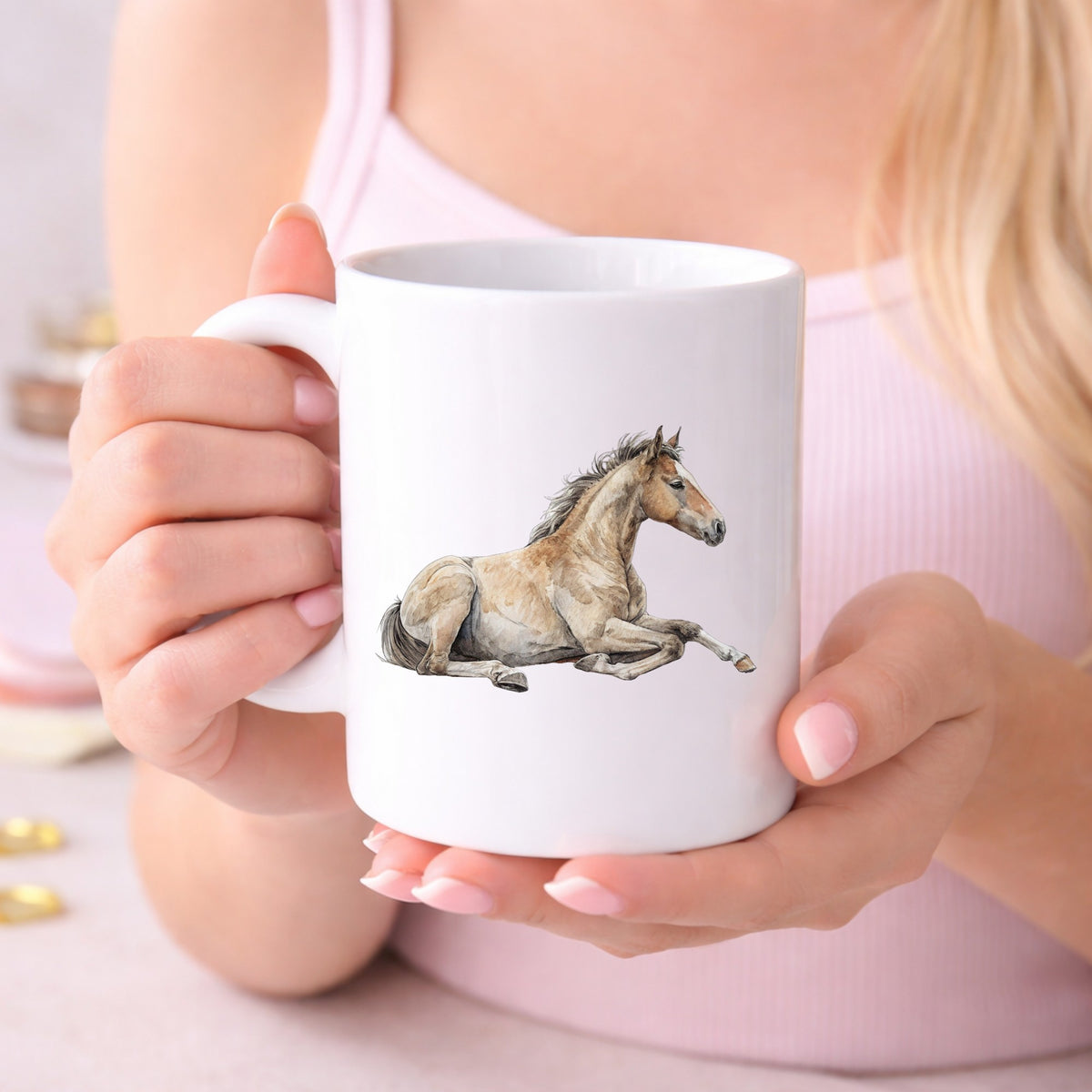 Buckskin Foal Lying Down UV DTF sticker applied to a white coffee mug held in both hands