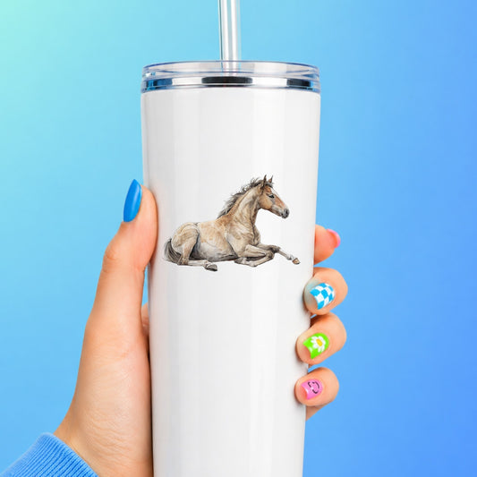 Buckskin Foal Lying Down UV DTF sticker applied to a white straw tumbler on a blue background