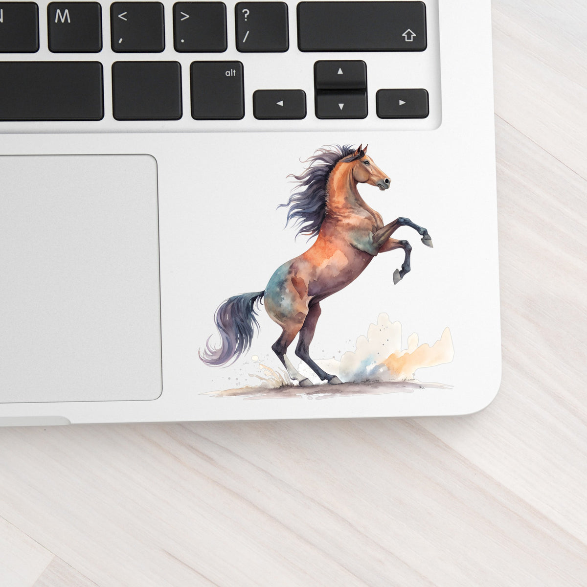 Bay Horse Rearing Up UV DTF sticker applied to a silver laptop beside the keyboard