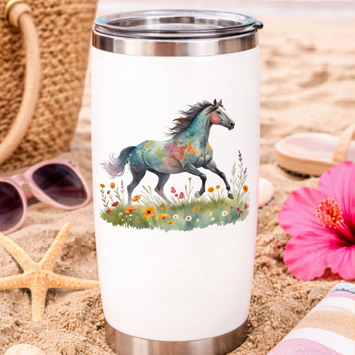 Floral Horse Running Through Wildflowers UV DTF sticker applied to a white travel tumbler on beach sand