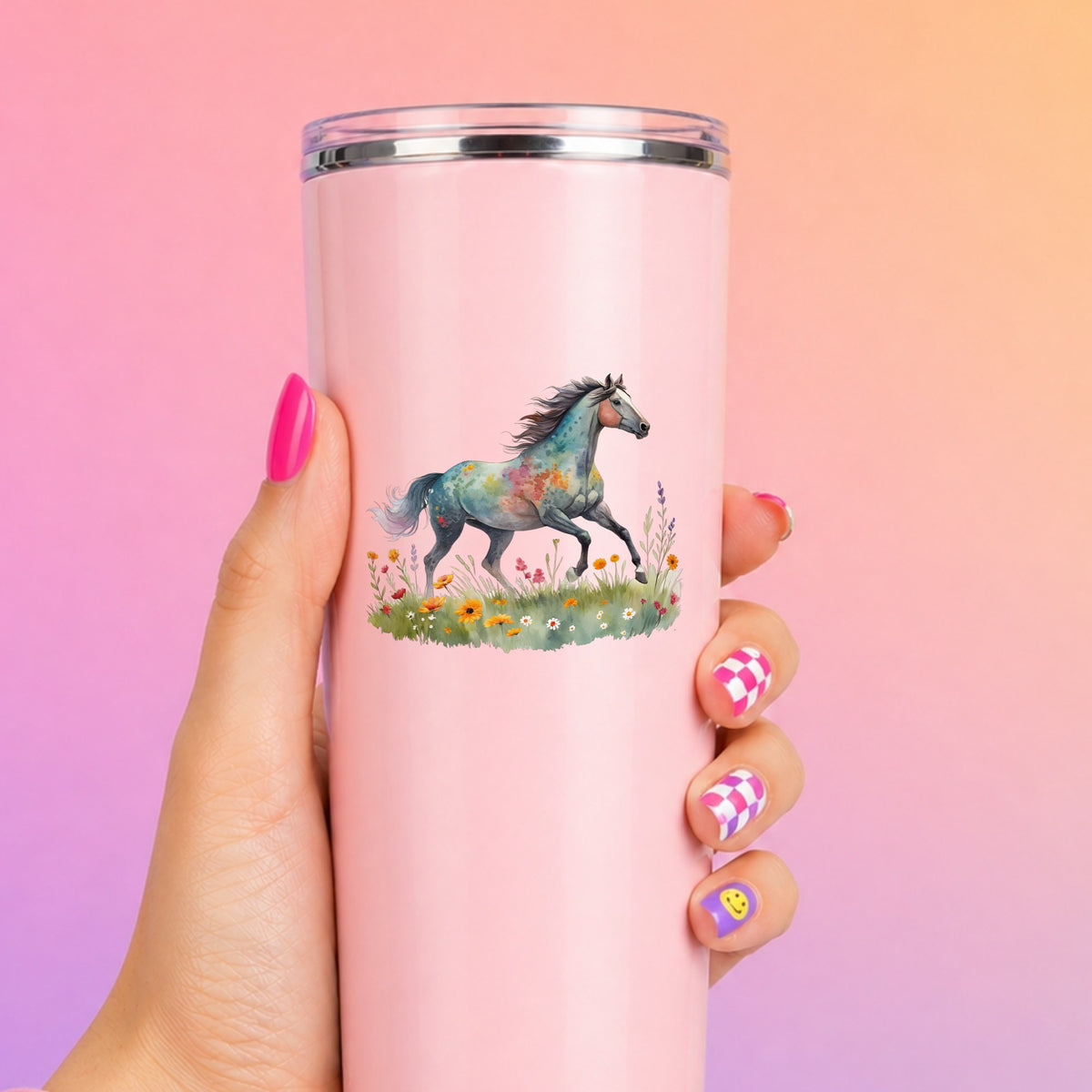 Floral Horse Running Through Wildflowers UV DTF sticker applied to a tall pink tumbler on a pink and orange background