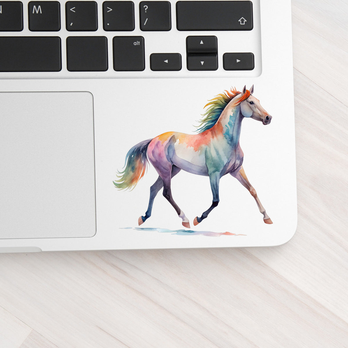 Rainbow Mane Horse Trotting UV DTF sticker applied to a silver laptop beside the keyboard