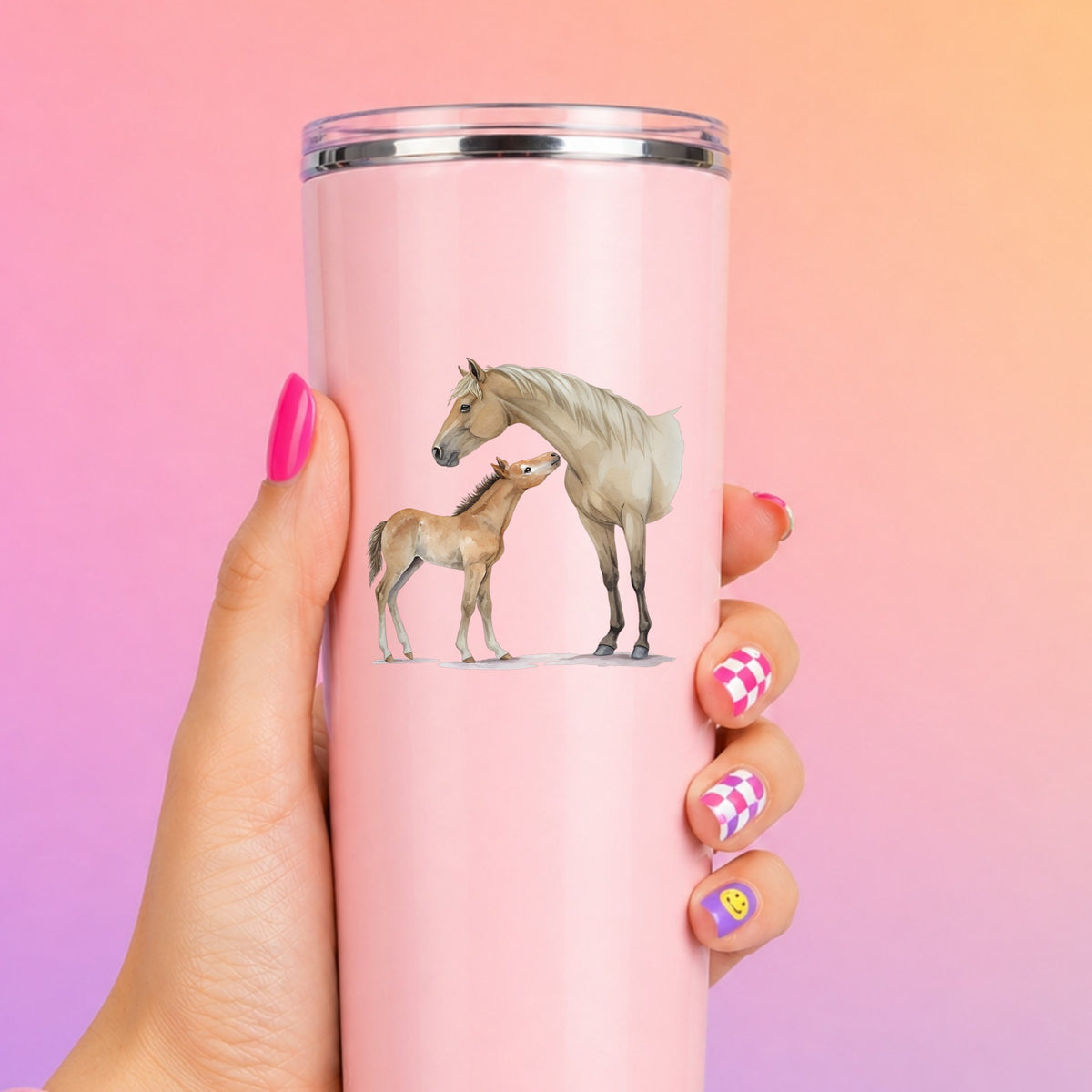 Mare Nuzzling Foal UV DTF sticker applied to a tall pink tumbler on a pink and orange background