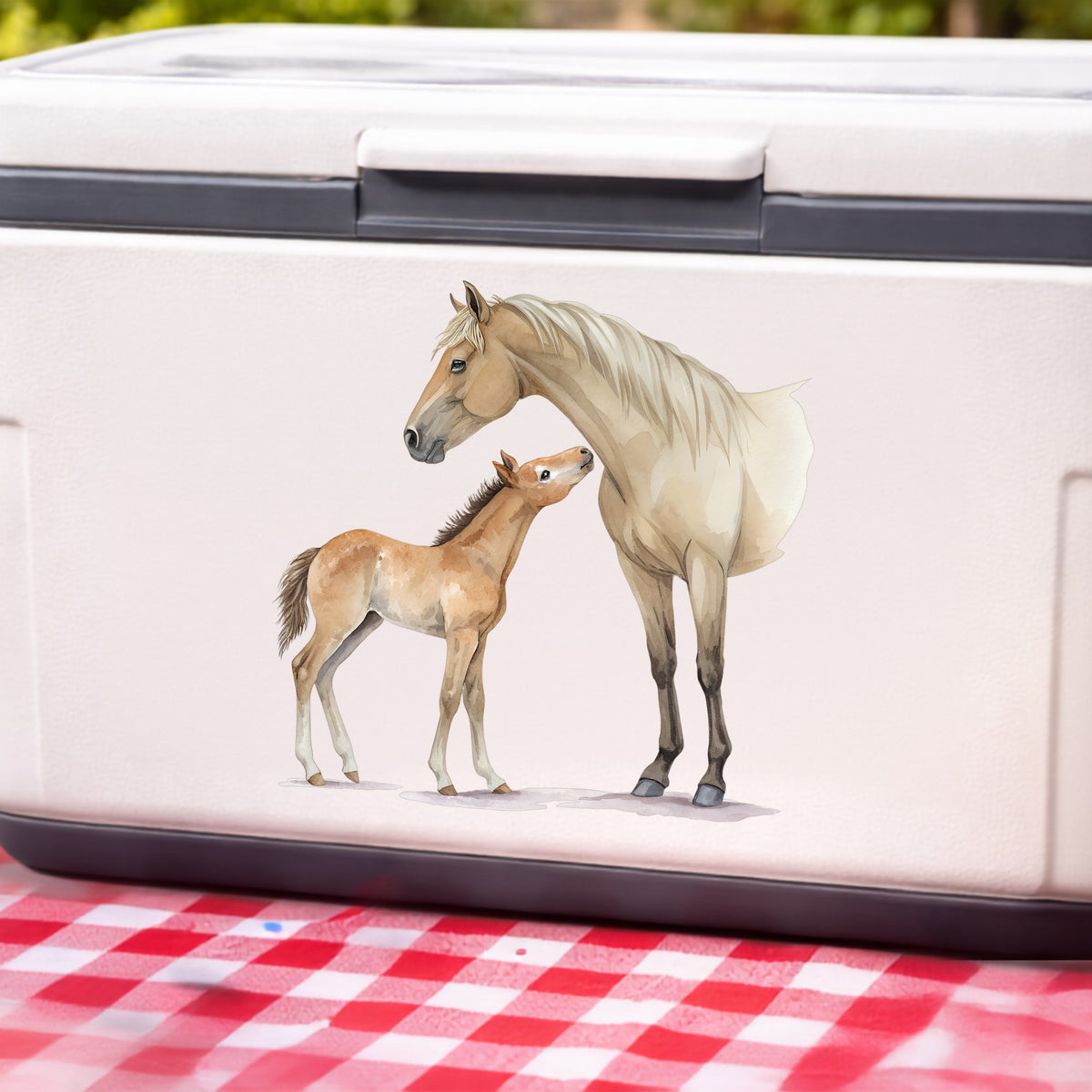 Mare Nuzzling Foal UV DTF sticker applied to a white cooler on a red gingham cloth