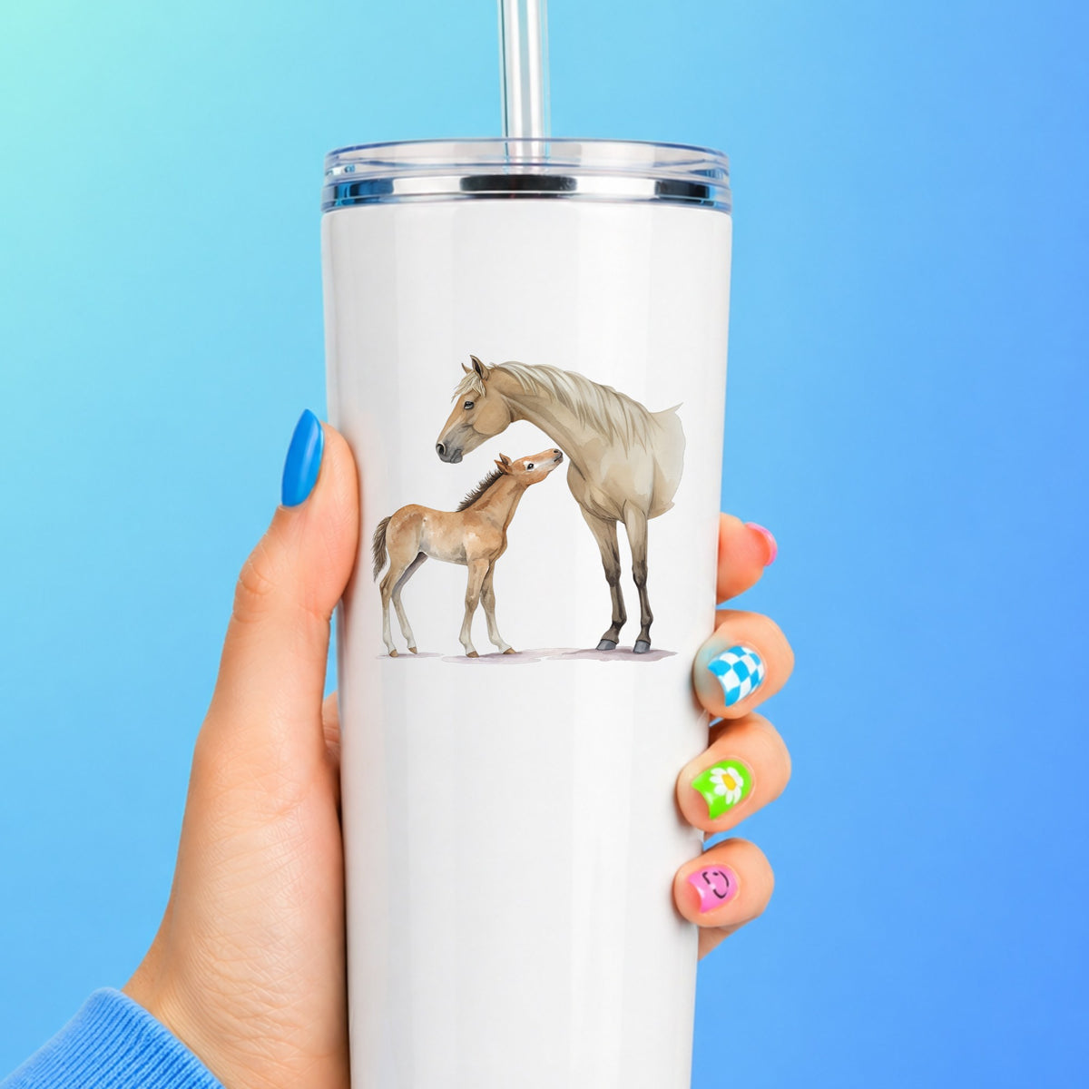 Mare Nuzzling Foal UV DTF sticker applied to a white straw tumbler on a blue background