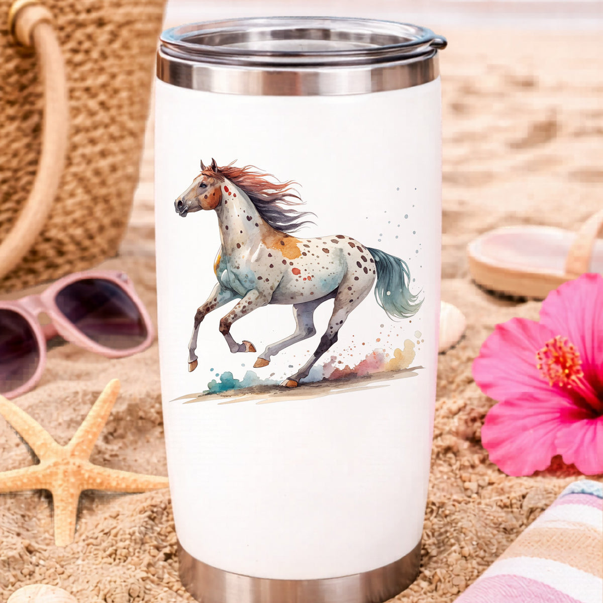 Appaloosa Spotted Horse Running UV DTF sticker applied to a white travel tumbler on beach sand