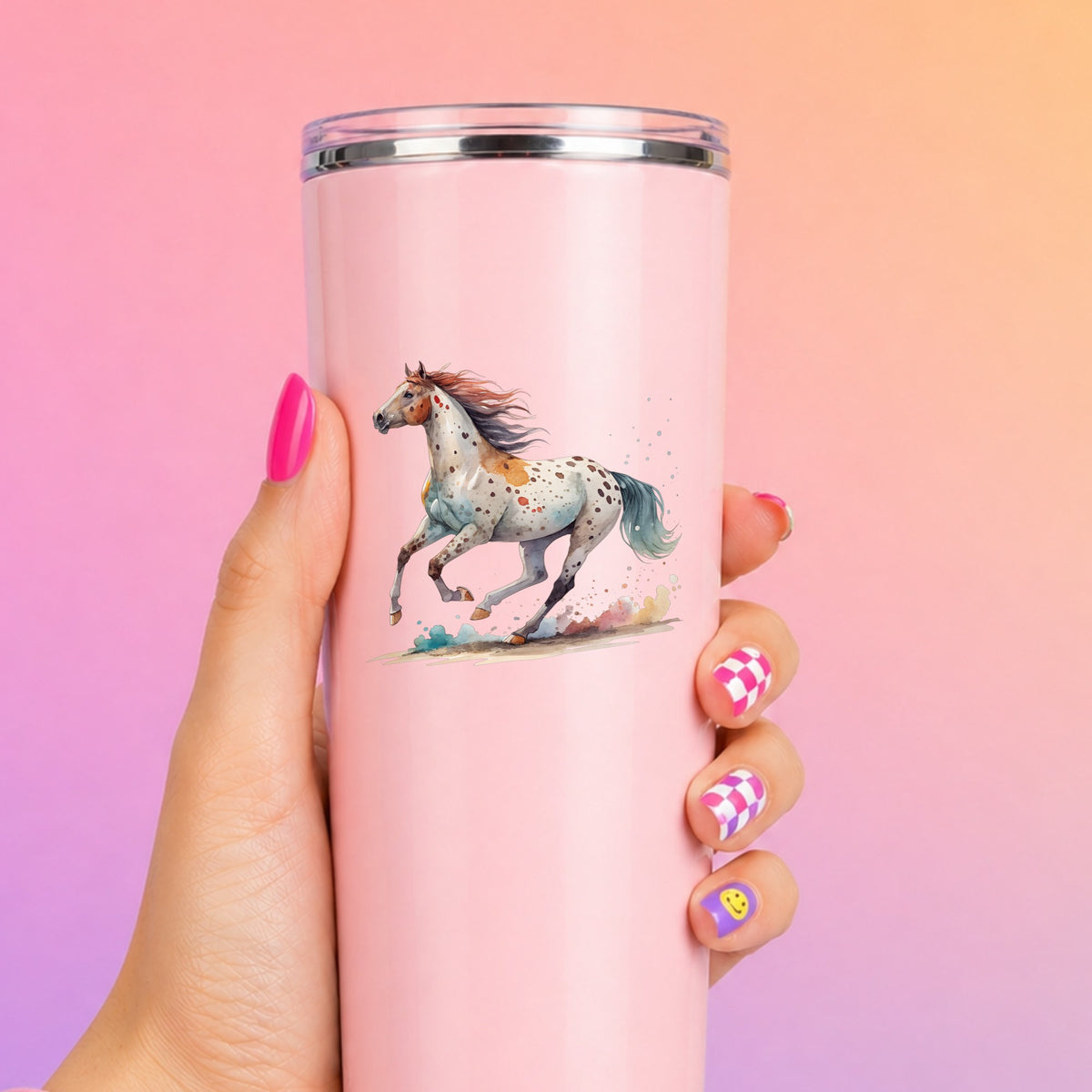 Appaloosa Spotted Horse Running UV DTF sticker applied to a tall pink tumbler on a pink and orange background