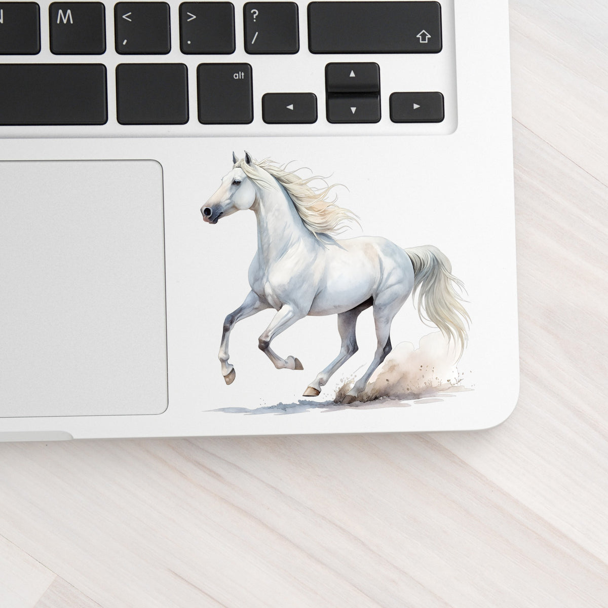 White Horse Galloping UV DTF sticker applied to a silver laptop beside the keyboard