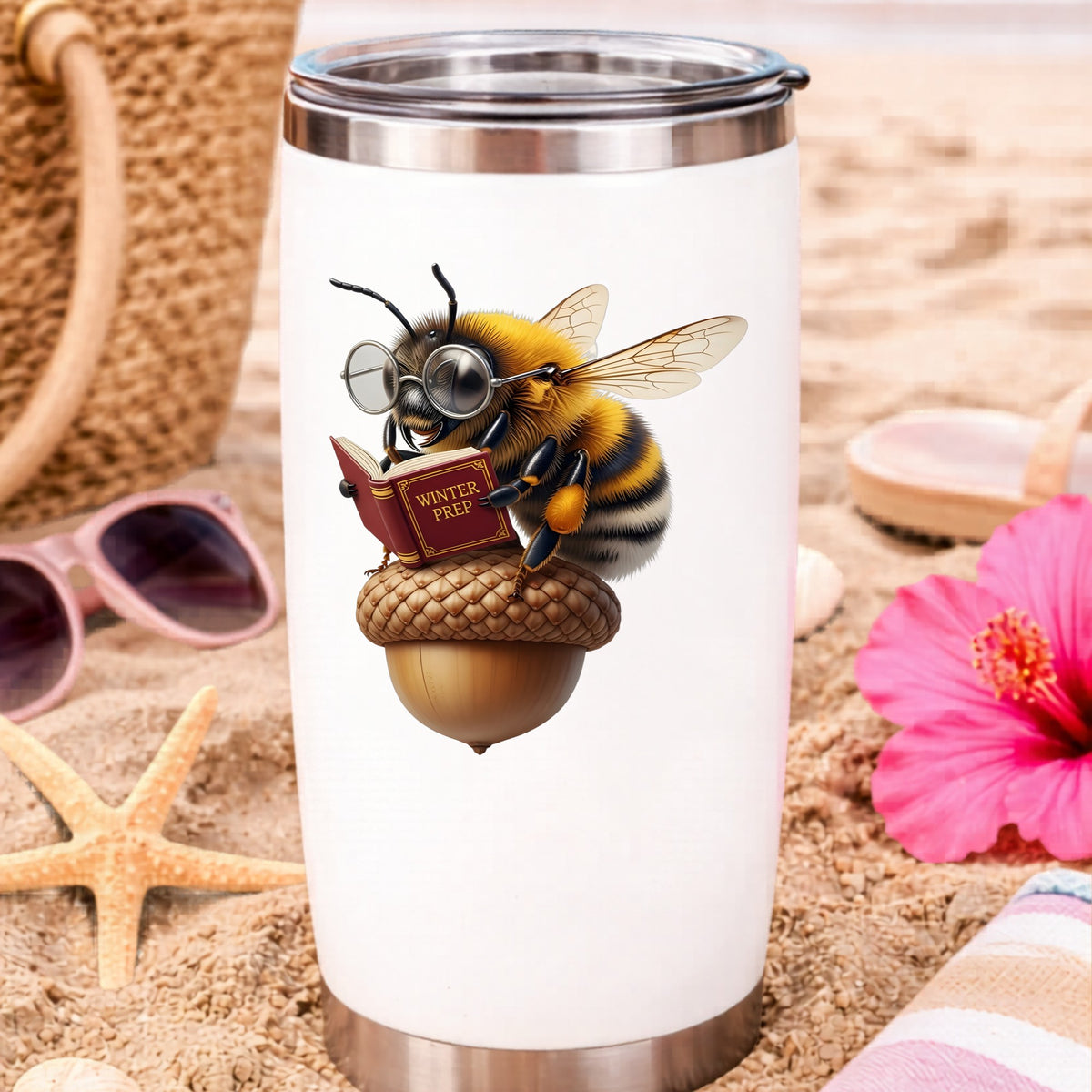 Bee Reading Book On Acorn UV DTF sticker applied to a white travel tumbler on beach sand