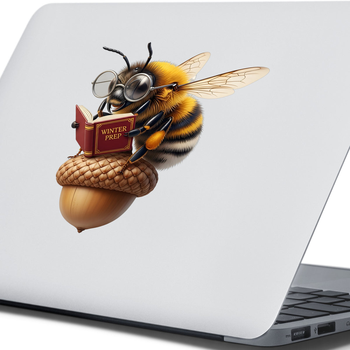 Bee Reading Book On Acorn UV DTF sticker applied to the lid of a silver laptop