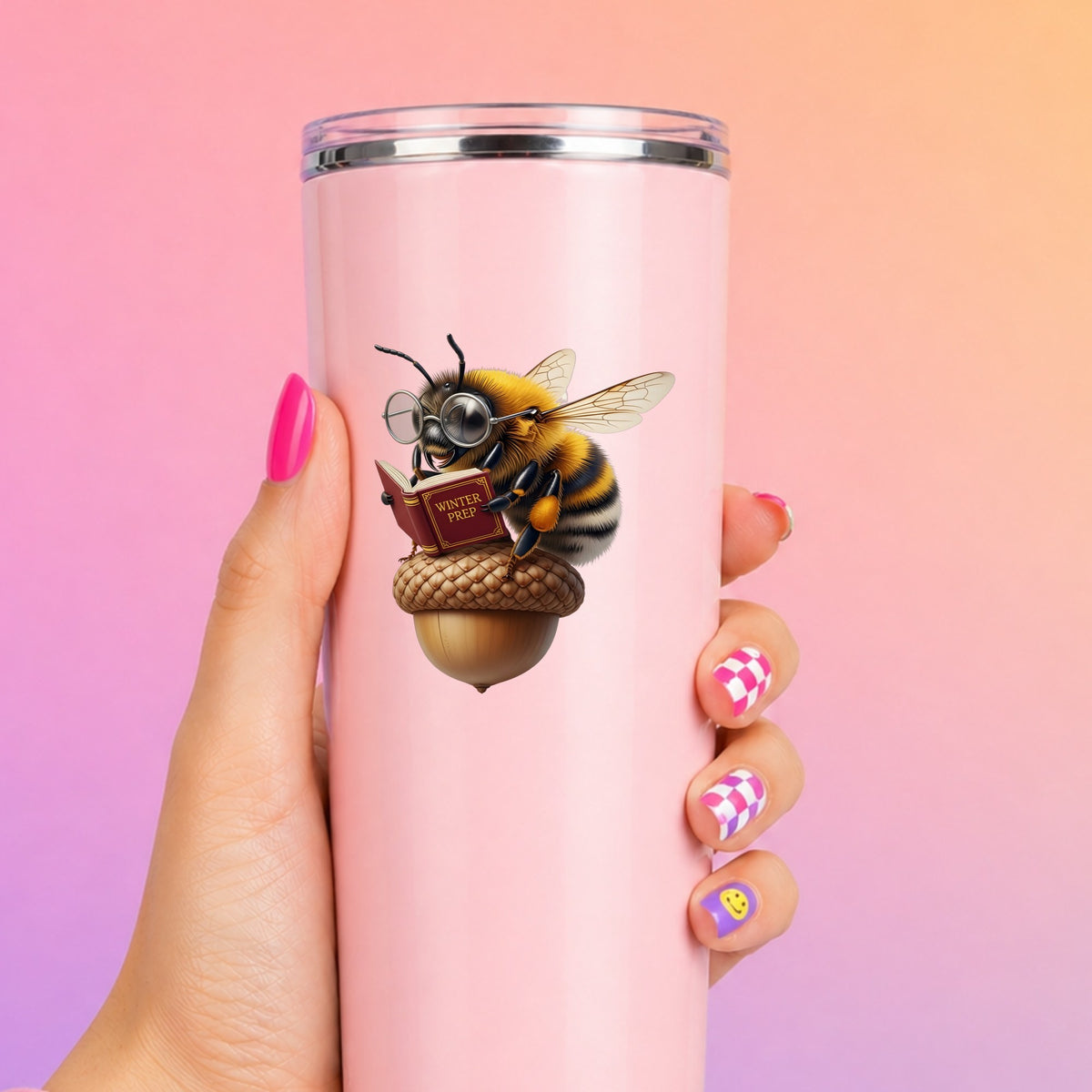 Bee Reading Book On Acorn UV DTF sticker applied to a tall pink tumbler on a pink and orange background