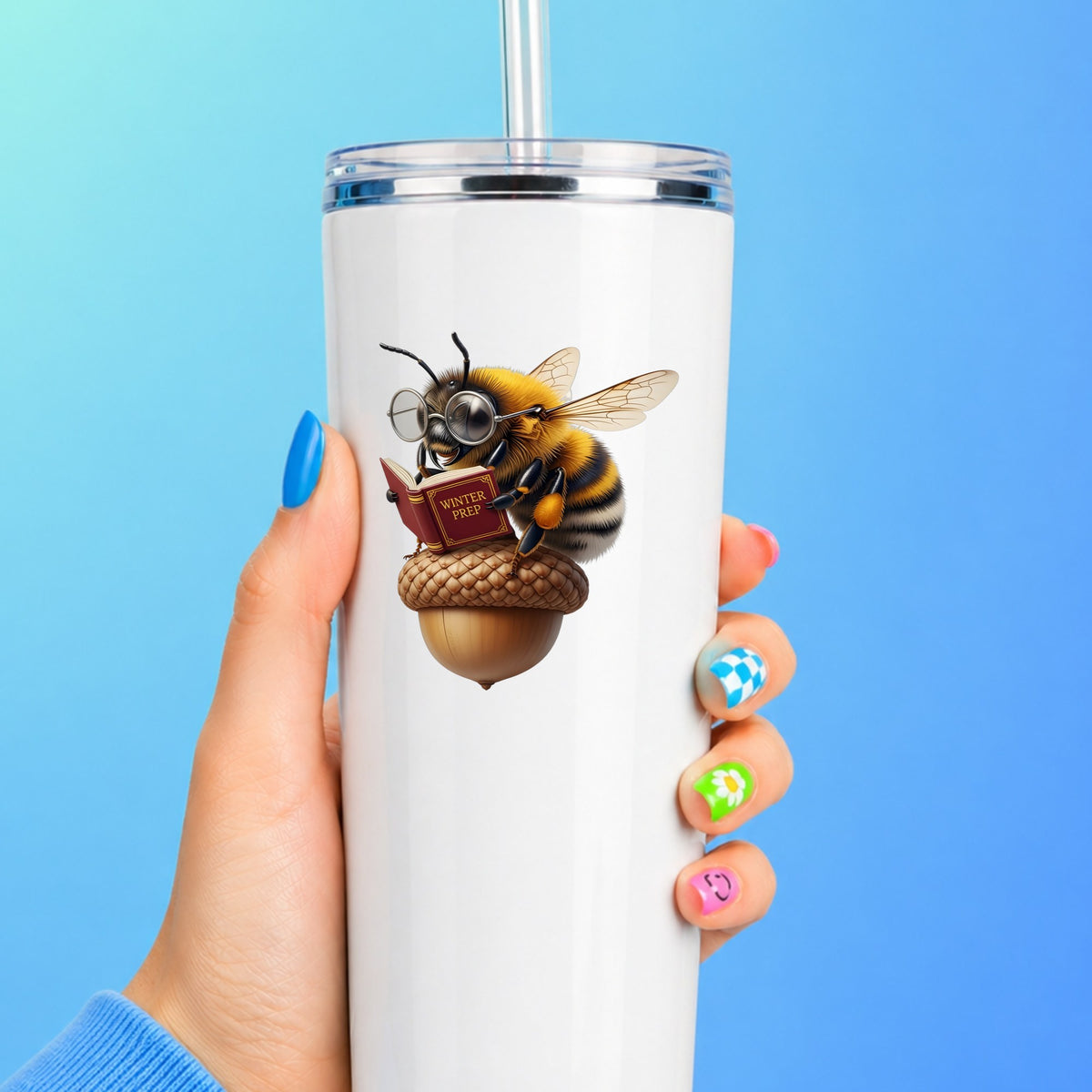 Bee Reading Book On Acorn UV DTF sticker applied to a white straw tumbler on a blue background
