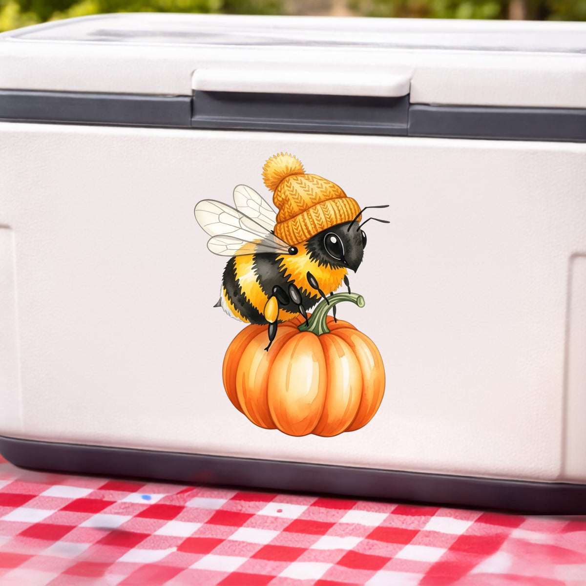 Bee In Orange Beanie On Pumpkin UV DTF sticker applied to a white cooler on a red gingham cloth