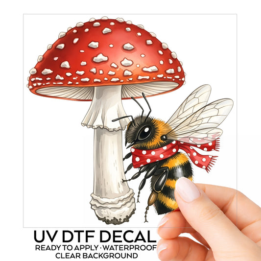 Bee With Red Mushroom UV DTF sticker on its backing card, held in hand