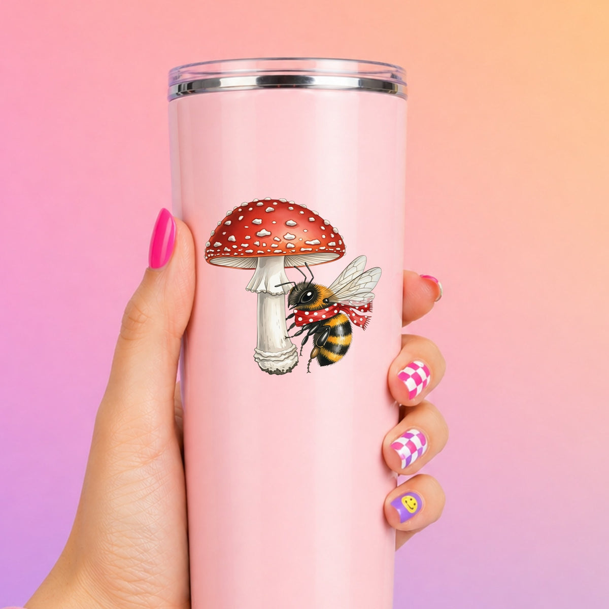 Bee With Red Mushroom UV DTF sticker applied to a tall pink tumbler on a pink and orange background