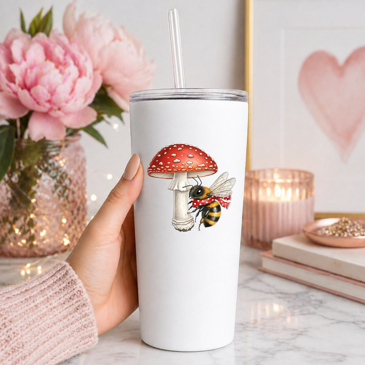 Bee With Red Mushroom UV DTF sticker applied to a white straw tumbler beside pink peonies