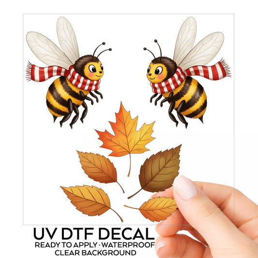 Two Bees With Autumn Leaves UV DTF sticker on its backing card, held in hand